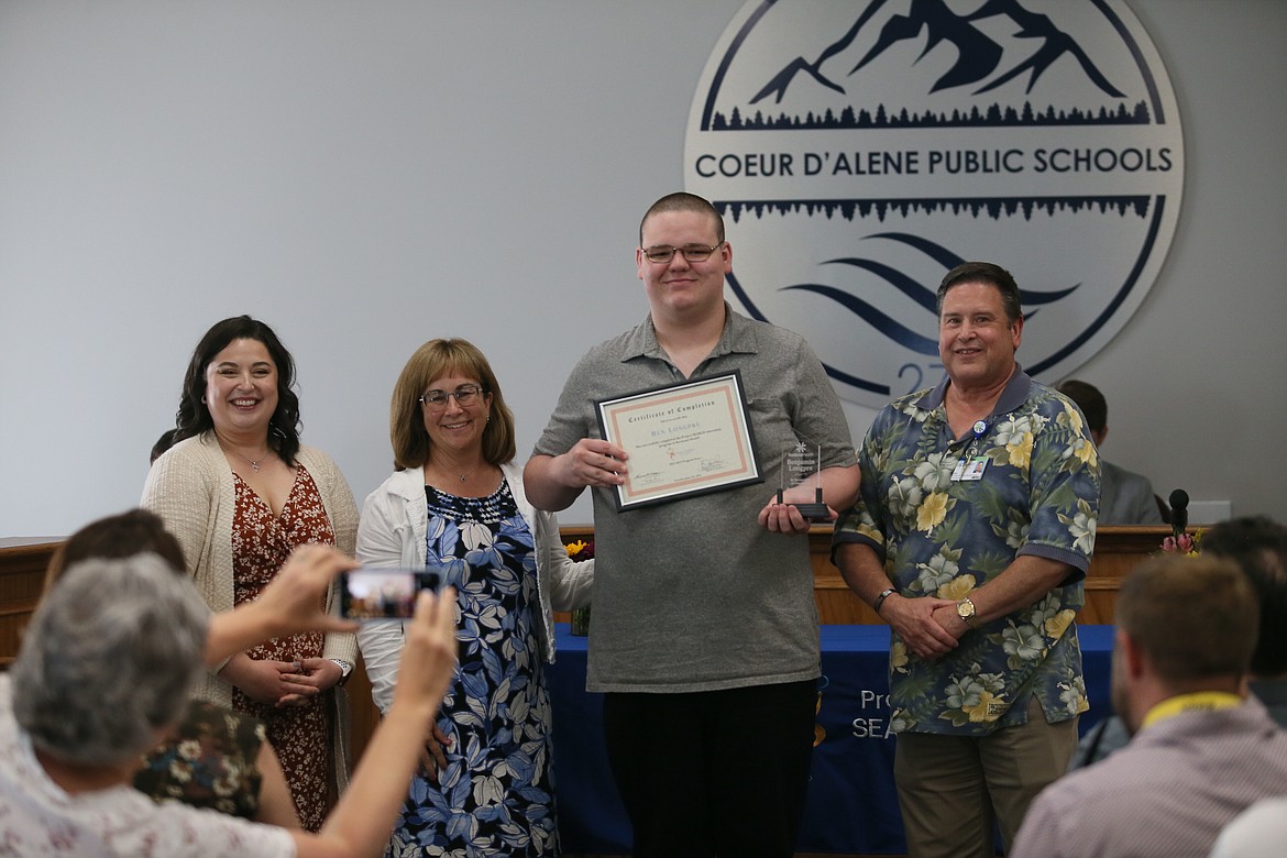 A proud mama snaps a photo Wednesday as Project SEARCH graduate Ben Longpre receives his certificate of completion. From left: Abbie Waters and Theresa Moran, Longpre and Skip Peterson.