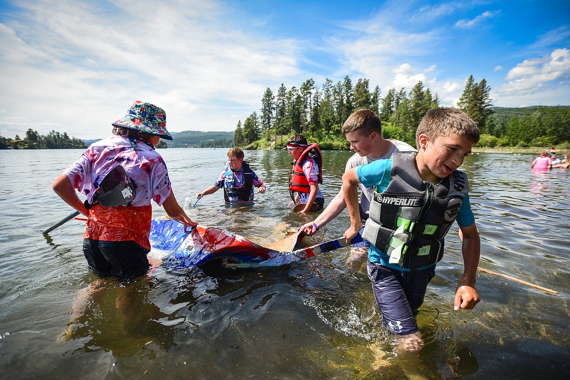 Somers Middle School sixth-graders Archer Haley, Destrey Lehman, Nolan Shaffer, Talon Steely and Trace Uskoski haul their sunken cardboard boat back to shore after it sunk during a race with classmates at Somers Bay on Thursday, June 8. (Casey Kreider/Daily Inter Lake)