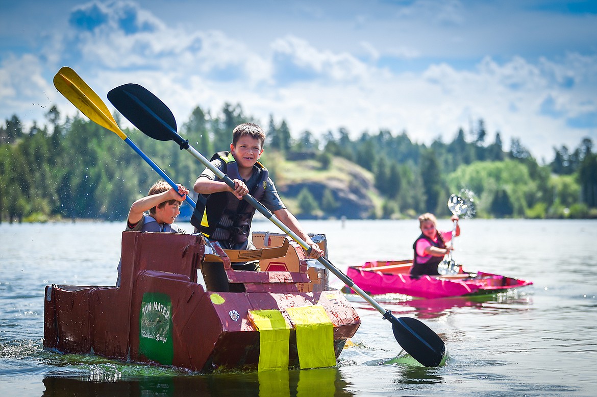 Somers Middle School sixth-graders Walter Gardner and Leo Simonson, of the Redneck Tow Mater team, and Addy Aiken, of the Flamingos team, race their cardboard boats in Somers Bay on Thursday, June 8. Also in the Tow Maters' team was Jonas Ek with Claire St. Jean and Lexi Herion also on the Flamingos team. (Casey Kreider/Daily Inter Lake)