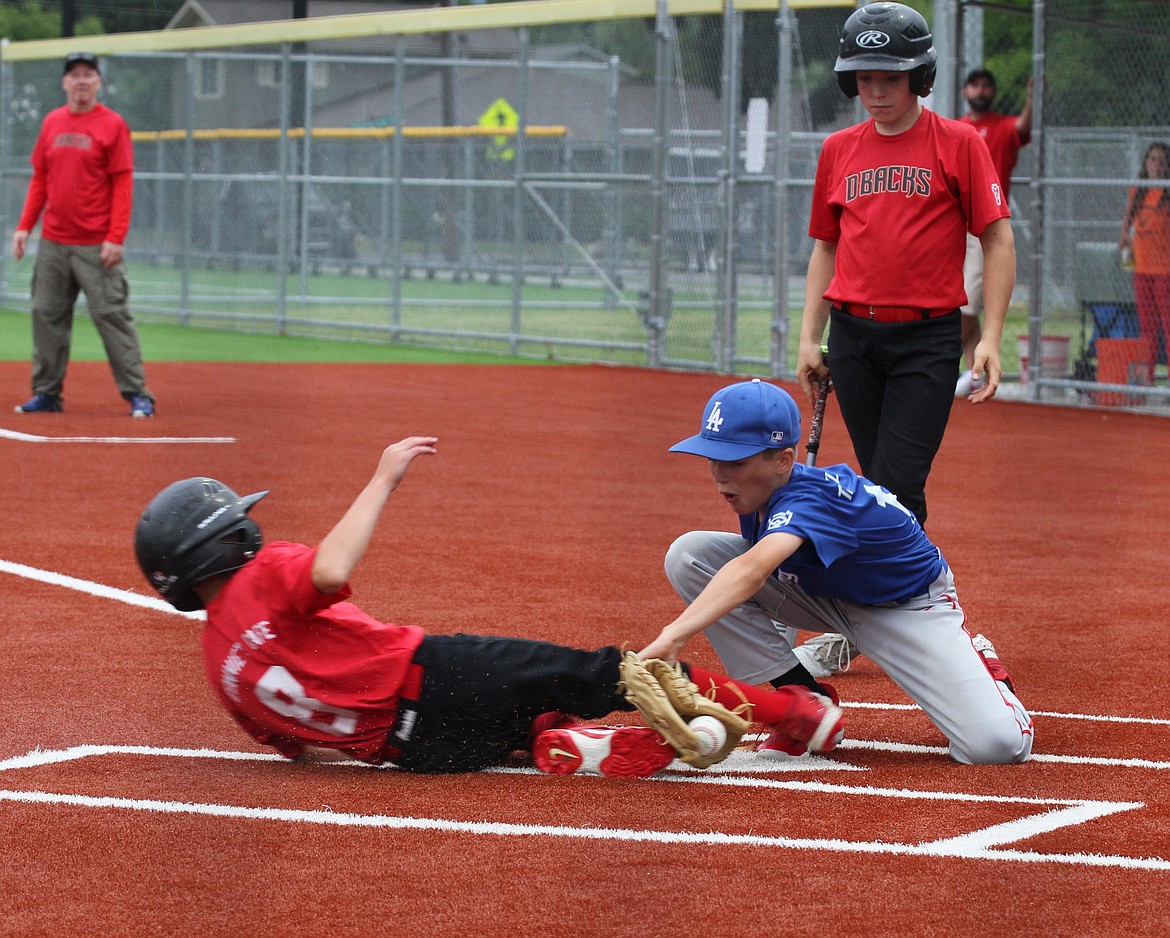 Kaleb Bogadi tags out Camden Clark at home in the Majors championship game.