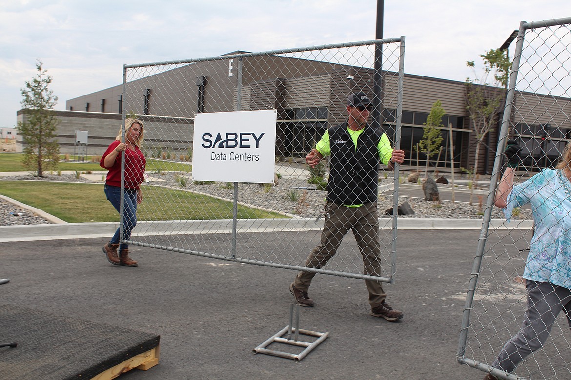 Sabey Data Center employees remove a section of fence, symbolizing the merger of two sections of the company’s Quincy site into one.