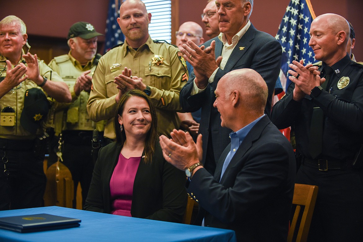 Gov. Greg Gianforte, U.S. Congressman Ryan Zinke, and members of the Flathead County Sheriff's Office applaud Kalispell Republican Rep. Courtenay Sprunger during a bill signing ceremony at the Flathead County Courthouse on June 9, 2023. (Kate Heston/Daily Inter Lake)