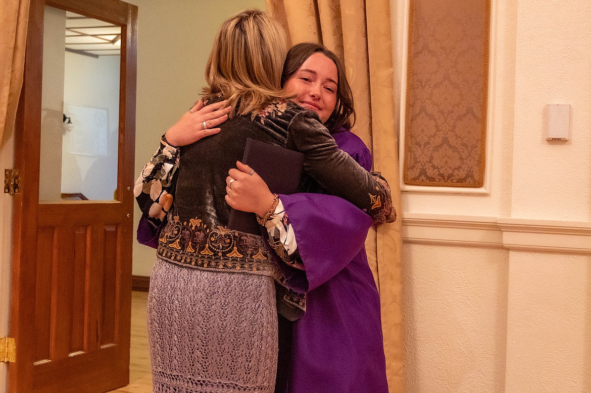 Tallulah Stafford hugs science teacher Brenda Woodward after giving her her graduation cap.