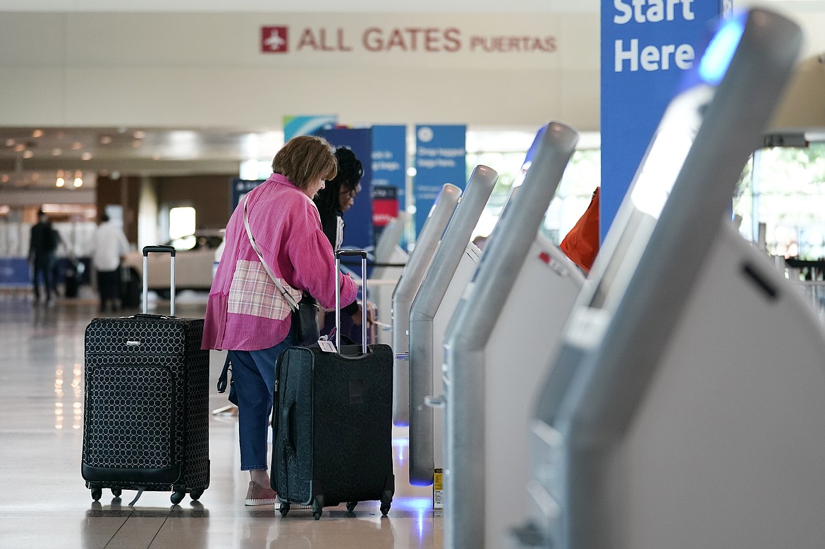 FILE - Travelers use the kiosk by the ticketing gate as they prepare for travel from Love Field airport, May 19, 2023, in Dallas. Lawmakers are considering rolling back an Obama-era rule that requires airlines to show the total price of a ticket upfront in advertising, while also tweaking training requirements for airline pilots and making other changes in a massive bill covering the Federal Aviation Administration. (AP Photo/Tony Gutierrez, File)