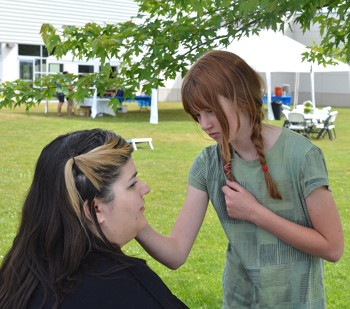 Marguerite Brenner gives Bailee Hawkins a new look during the 10th anniversary celebration at Mission Valley Aquatics and Fitness. Face-painting, in addition to free ice cream, yard games and, of course, swimming, were among the offerings. (Kristi Niemeyer/Leader)