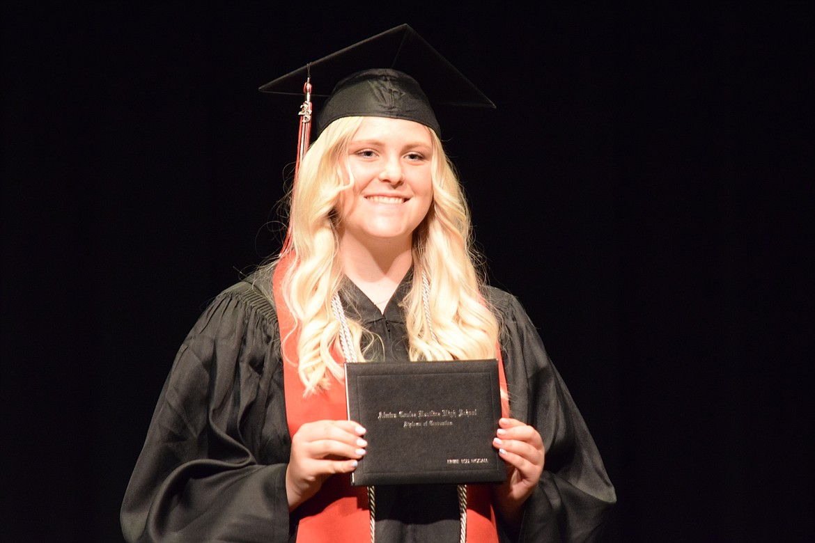 ACH High School graduate Kenzie McCall holds up her diploma after receiving it during the school’s 2023 graduation ceremony on June 10.