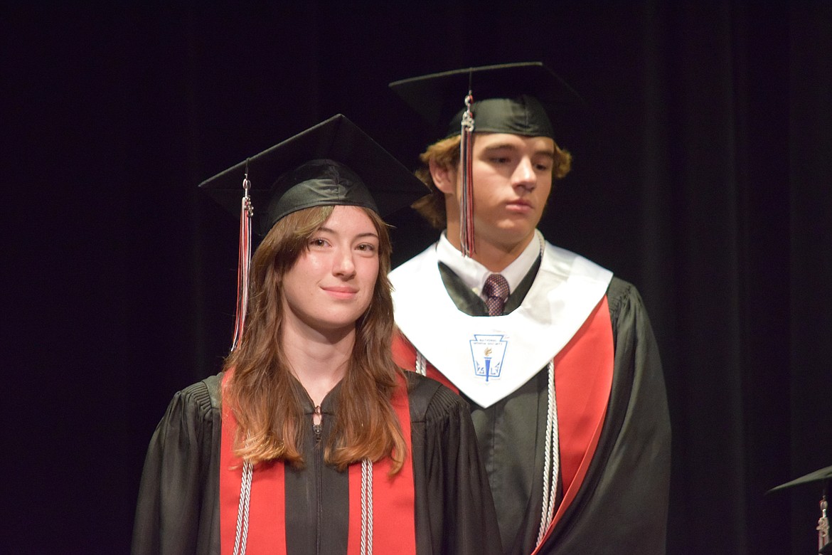 ACH High Scholl graduating seniors Chloe Jensen, front, and Tristen Wood, rear, stand while being recognized during the school’s graduation ceremony on June 10.