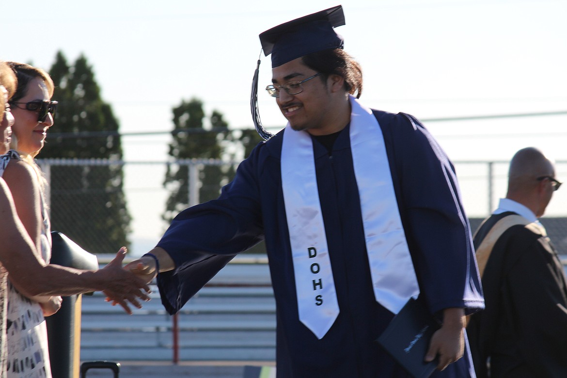 A Desert Oasis High School graduate gets a handshake from Othello School Board members.