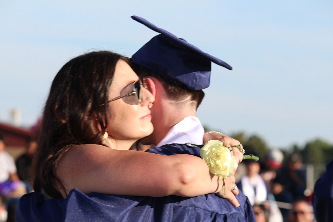 A graduate gets a hug from a family member during Desert Oasis High School graduation.