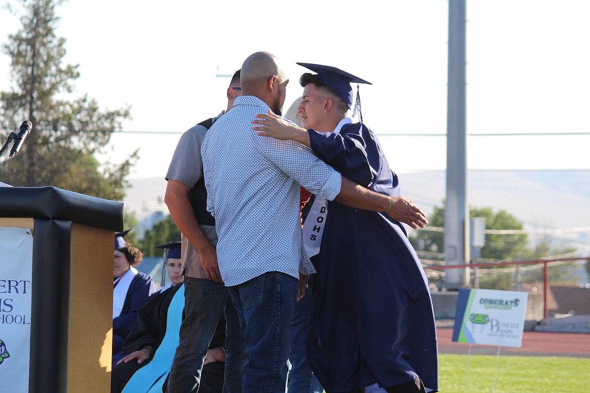 Jose Barragan, center, recipient of a scholarship in memory of Benny Medina, hugs a member of Medina’s family at Desert Oasis High School graduation June 5.