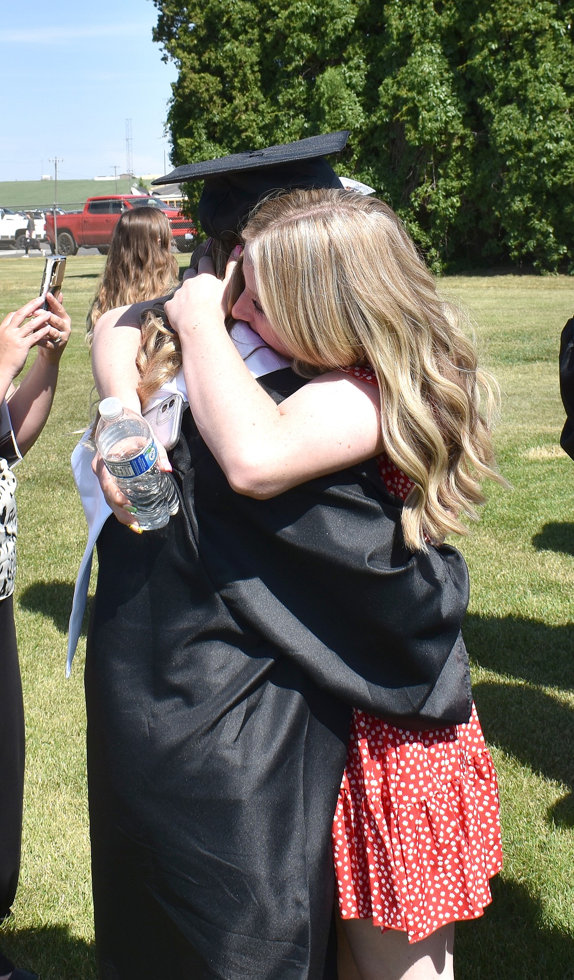 New Lind-Ritzville graduate Myra Miller, left, hugs her friend Madison Cameron.