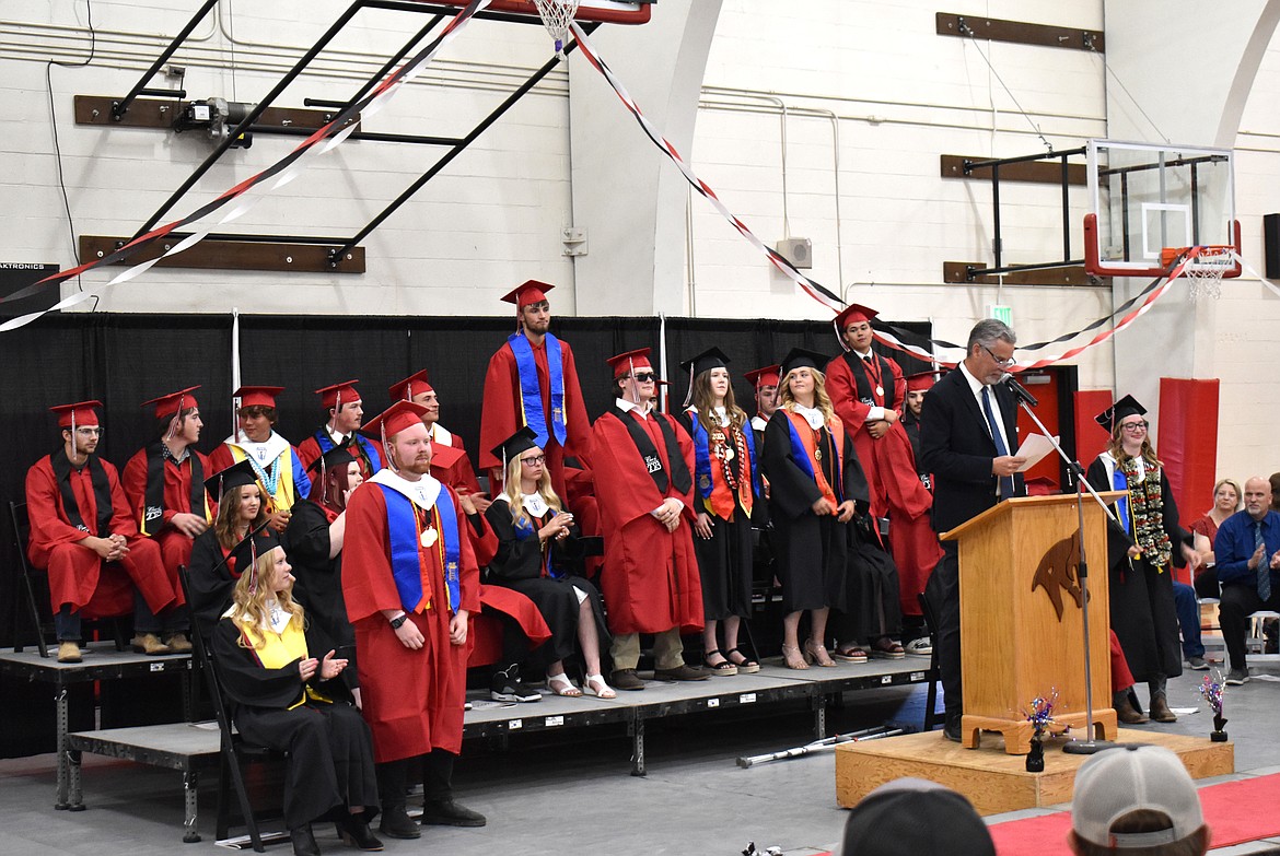 Lind-Ritzville High School Principal Kevin Terris calls on seniors to stand and acknowledge their various accomplishments as part of the graduation ceremony June 3.