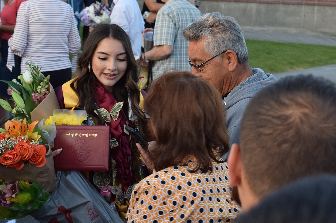 A 2023 MLHS grad is surrounded by family and friends as she holds congratulatory gifts she’d been presented with. Many of the young men and women were given balloons, cards, flowers and candy in celebration of their accomplishments.