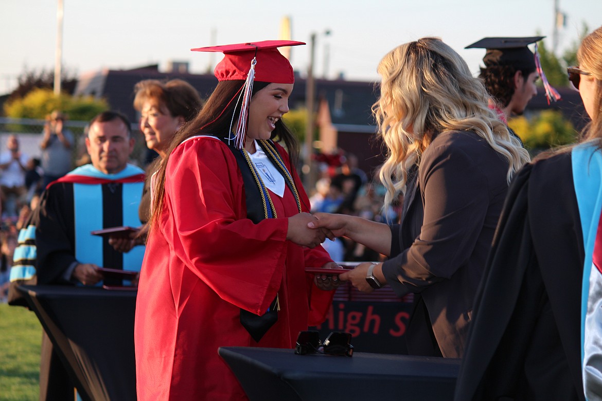 An excited Othello High School graduate receives her diploma from Othello School Board member Thalia Lemus, left, in graduation ceremonies on June 2.