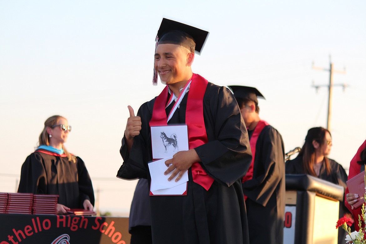 Diploma in hand, a member of the Othello class of 2023 gives a thumbs-up to his family and friends.