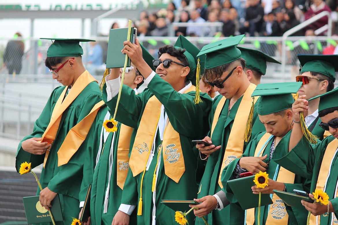 Quincy graduation 12:
CHERYL SCHWEIZER/COLUMBIA BASIN HERALD
A Quincy senior commemorates graduation with a livestream.