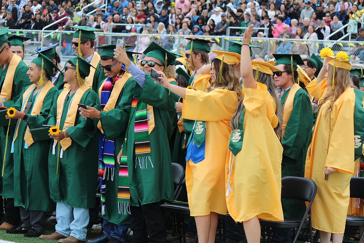 Quincy High School graduates commemorate the moment with selfies.