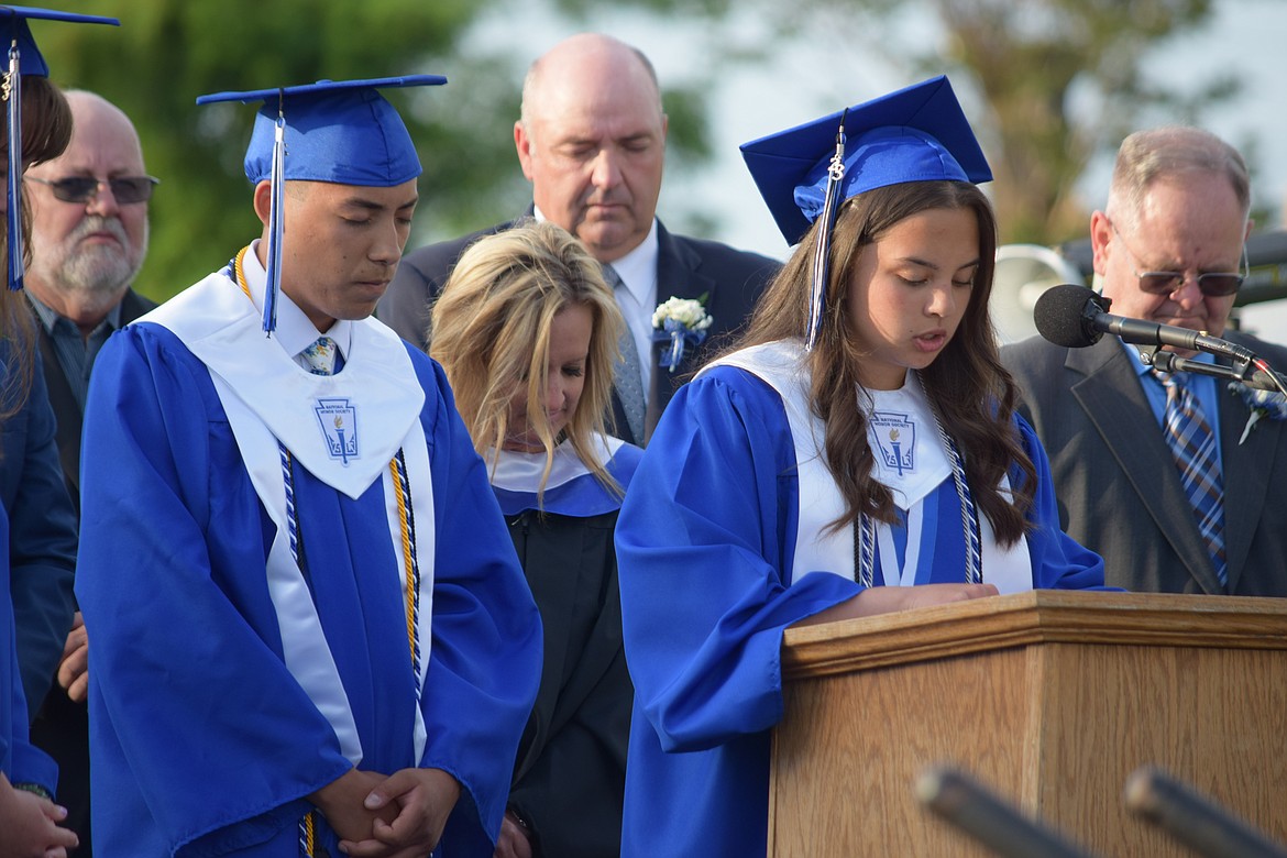 Warden High School graduating senior Tamar Rojas Lizagarra prays in Spanish as part of the district’s 2023 graduation ceremony. The English version of the prayer was said by fellow graduating senior Abrahan Barajas-Campos, left.