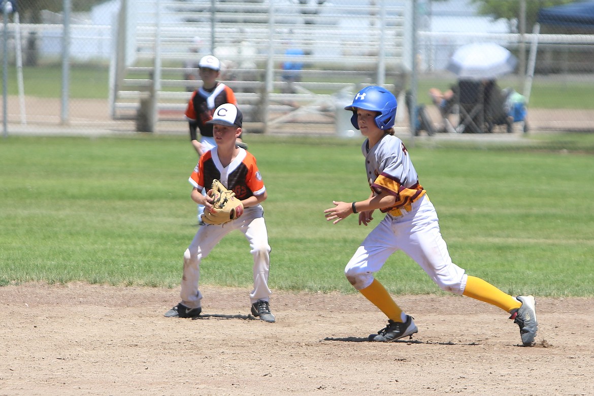 A baserunner for the 11U Moses Lake All-Stars, right, darts toward third base at the Pete Doumit Memorial Tournament on Sunday.