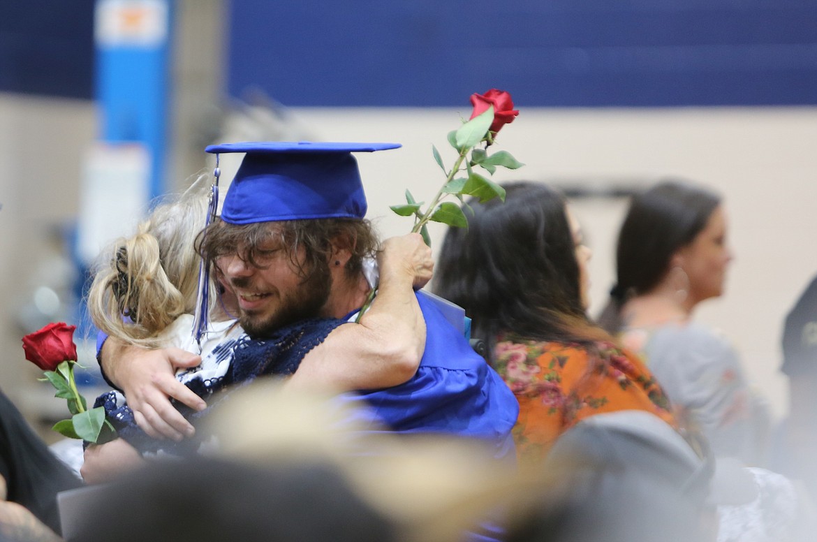 A Soap Lake graduate passes a rose during the rose ceremony at Saturday’s graduation.