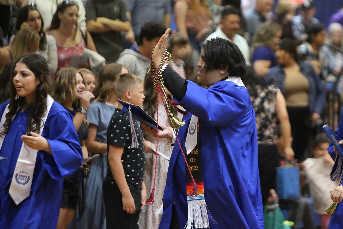 A Soap Lake graduate waves to the crowd after Saturday’s graduation ceremony.