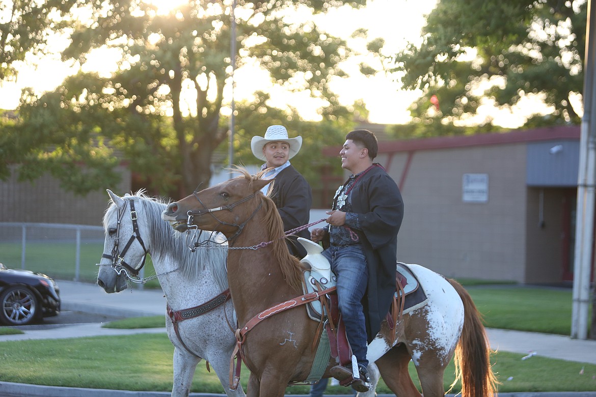 A pair of Wahluke graduates ride down Road S SW on horseback during the graduation parade.