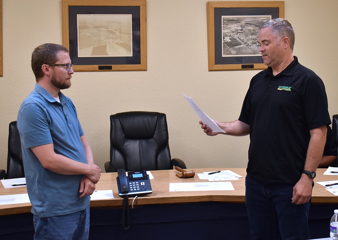 Royal City Finance Director Shilo Christensen, left, administers the oath of office to incoming City Council Member Ryan Piercy at Monday’s council meeting.