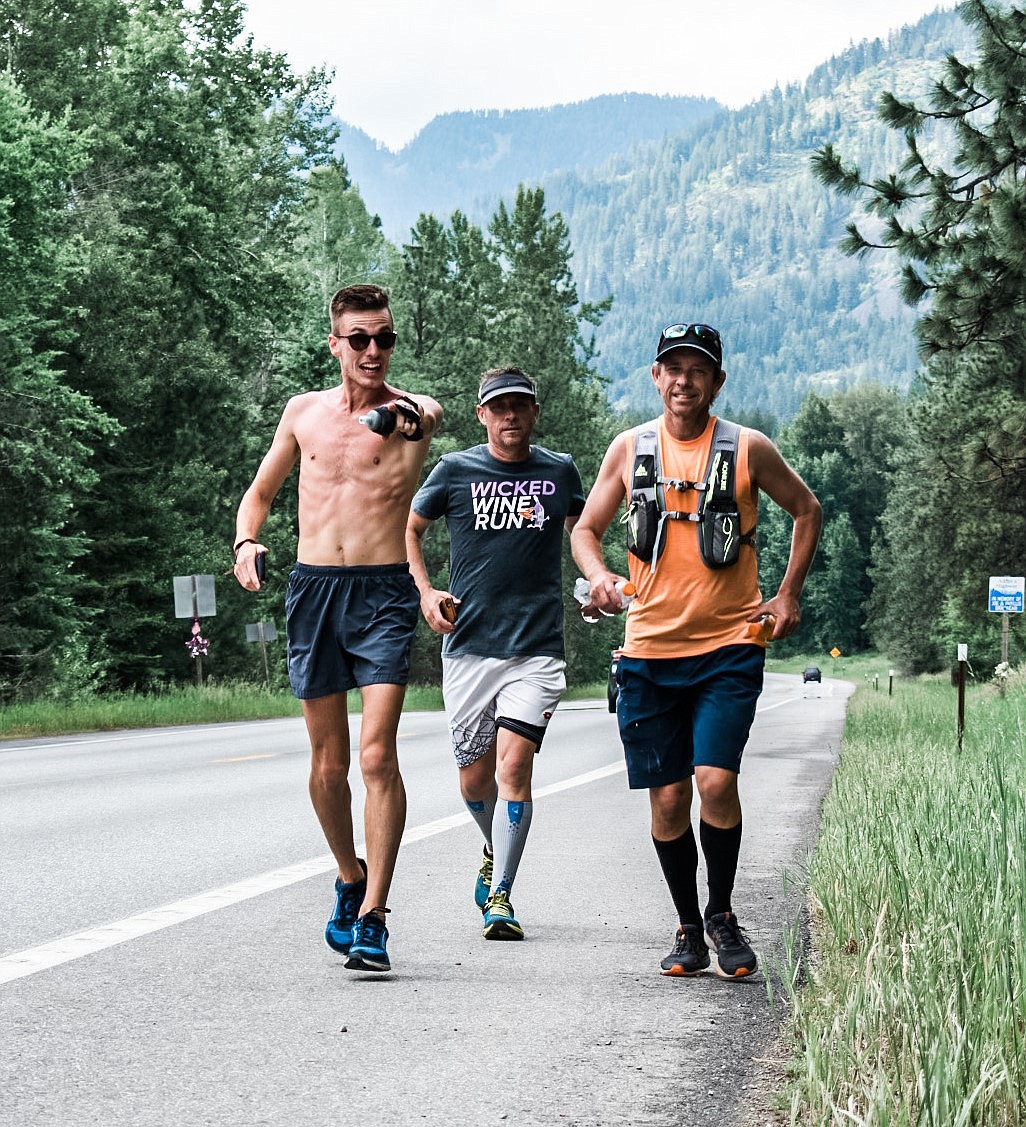 Christian Kuplack, Mark Latham, and Tom Latham run across a stretch of highway in Idaho.