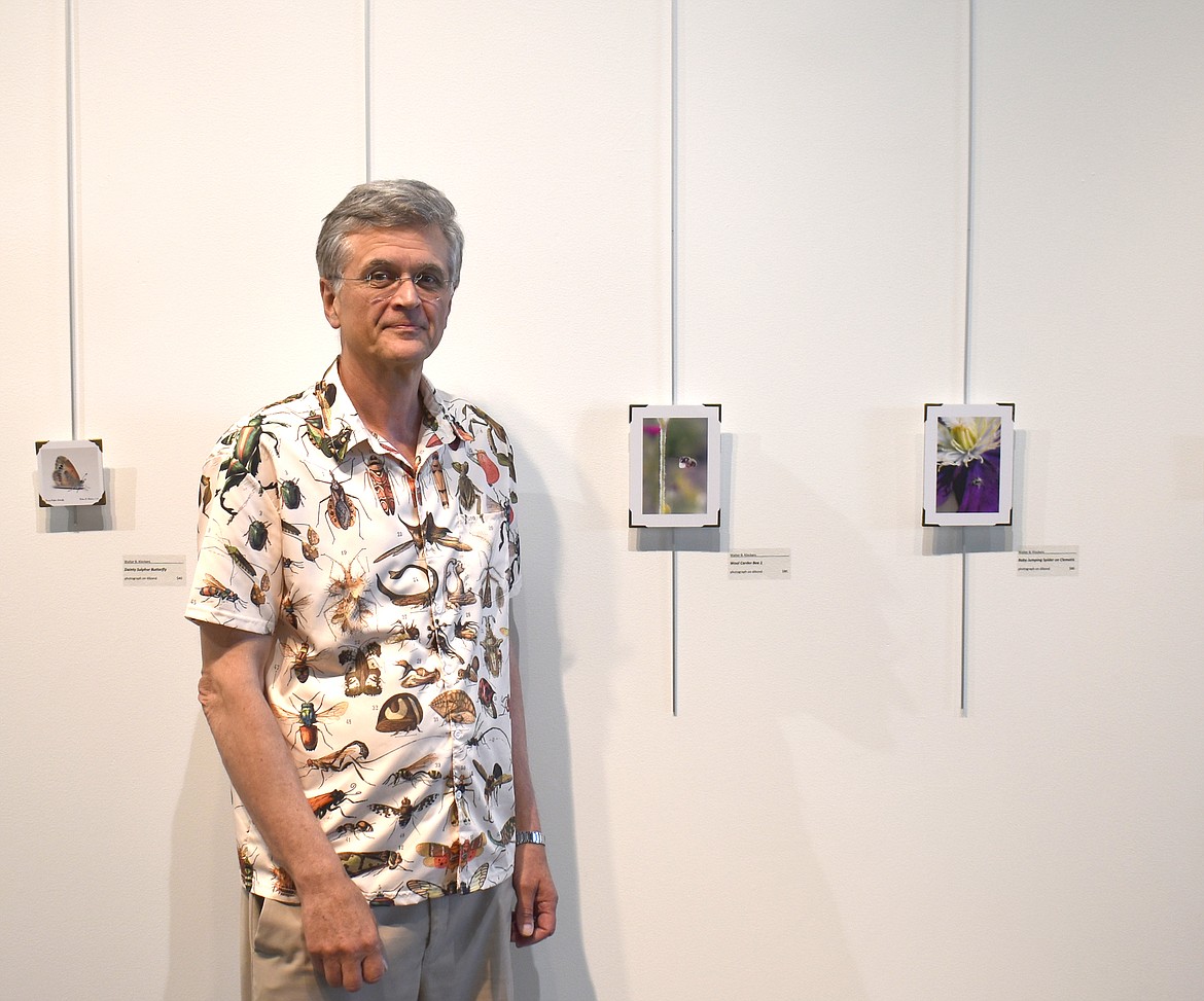 Moses Lake pastor and photographer Walter Klockers stands among his macro photos, currently on exhibit at the Moses Lake Museum & Art Center. Klockers’ insect-festooned shirt was a gift from his wife Jeannie, he said, who tolerates but does not share  his passion for creepy-crawly creatures.