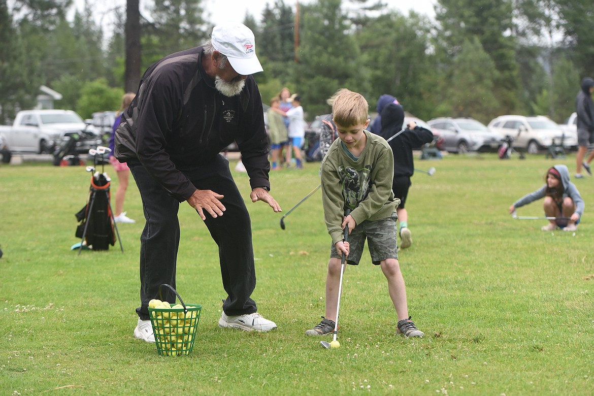 Dann Rohrer works with young golfer Owen Teisberg during the youth golf clinic Wednesday morning at Cabinet View Golf Course. (Scott Shindledecker/The Western News)