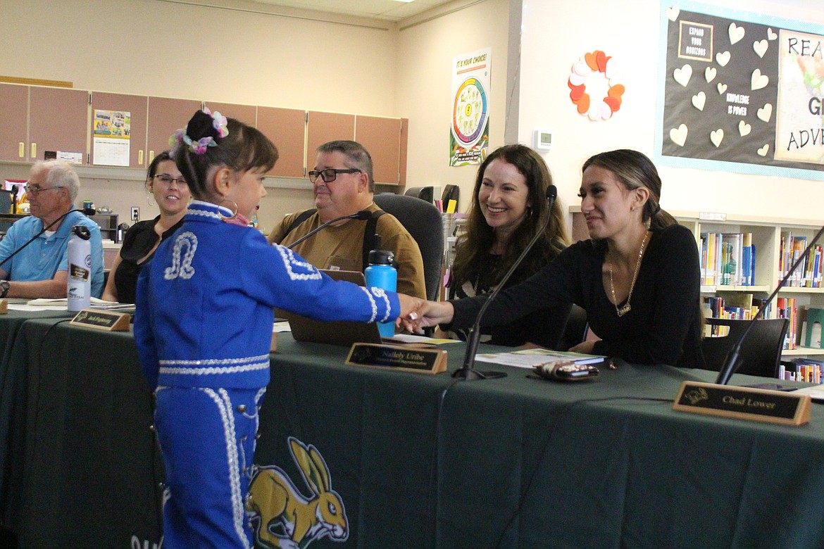 Kataleya Garcia, left, shakes hand with Nailely Uribe, right, student representative to the Quincy School Board, after Garcia’s performance at the board meeting Tuesday. Board members are interested in ideas to get more parental involvement in the schools.
