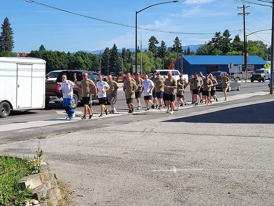 A Special Olympic athlete brings in the torch with law enforcement members.