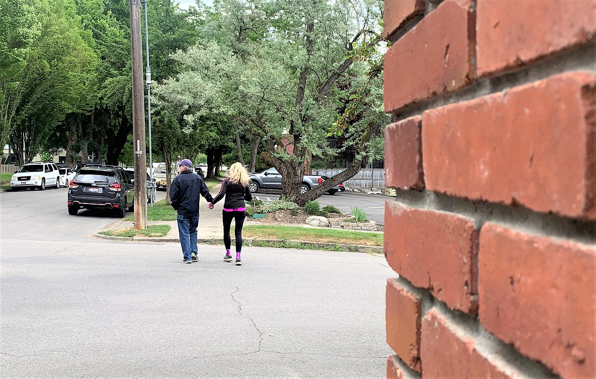 A couple cross the street at Fifth and Wallace, which is in the Garden District, on Wednesday.