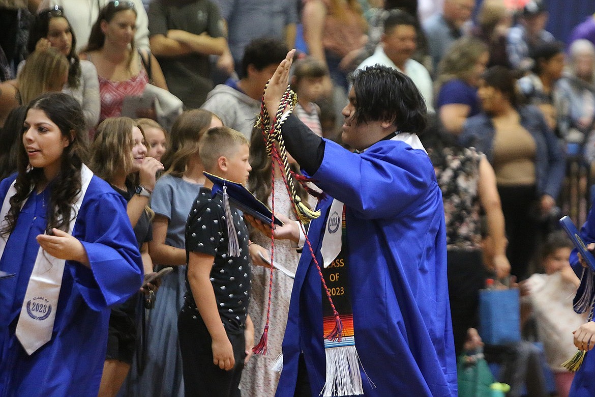 A Soap Lake graduate waves to the crowd after this year’s graduation ceremony.