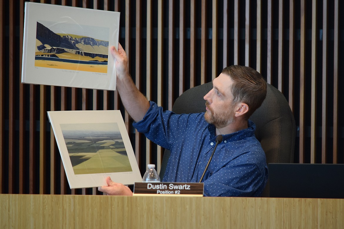 Moses Lake City Council Member Dustin Swartz holds up a pair of landscape paintings by local artist Kim Matthews Wheaton that the city is giving to the City of Yonezawa in Japan as a gift, part of the long sister-city relationship the two towns have.