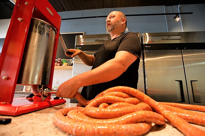 Ben Drake turns out a coil of sausages at his new downtown Coeur d'Alene shop, "Gentleman Sausages."