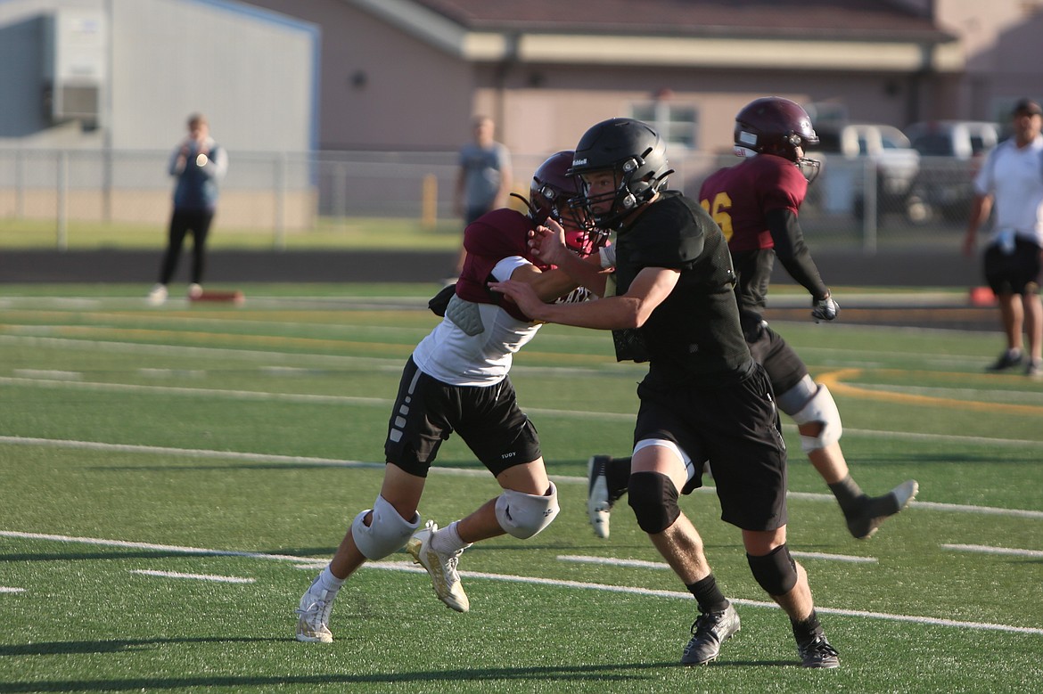 A Royal defender, in black, sheds off a Moses Lake blocker at Tuesday’s scrimmage in Royal City.