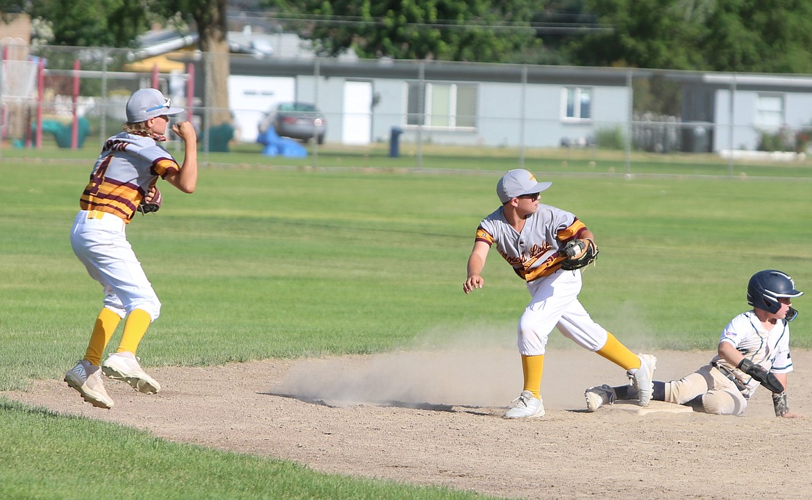 Players from the 11U Moses Lake All-Stars look toward an umpire in hopes a Lake Stevens baserunner will be called out at the Pete Doumit Memorial Tournament on Sunday.