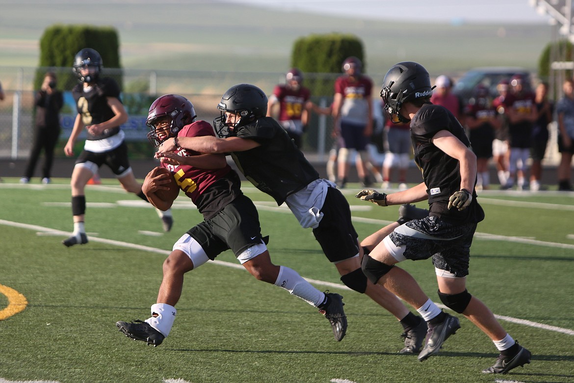 Moses Lake receiver Kyson Thomas, in maroon, shakes off Royal defenders at Tuesday’s scrimmage.