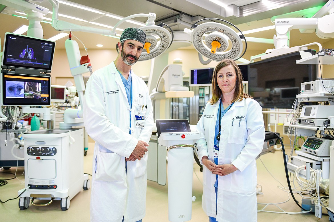 Dr. Luis Alberton, MD, a thoracic surgeon, and Dr. Bethany Weiler, MD, a pulmonary and critical care physician, with Logan Health's Ion endoluminal system, a robotic-assisted platform for minimally invasive biopsy in the lung on Friday, June 16. (Casey Kreider/Daily Inter Lake)