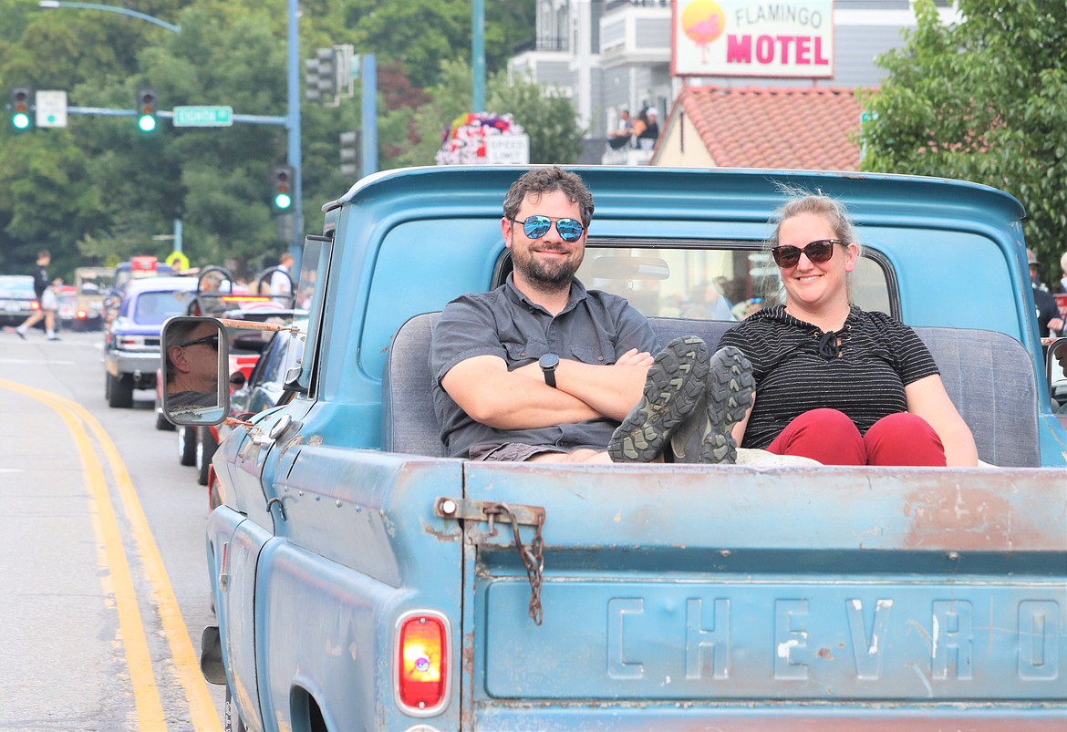 Michael and Kelli Cocks of Coeur d'Alene ride on the bed of a 1963 three-quarter ton Chevrolet truck in Car d'Lane.