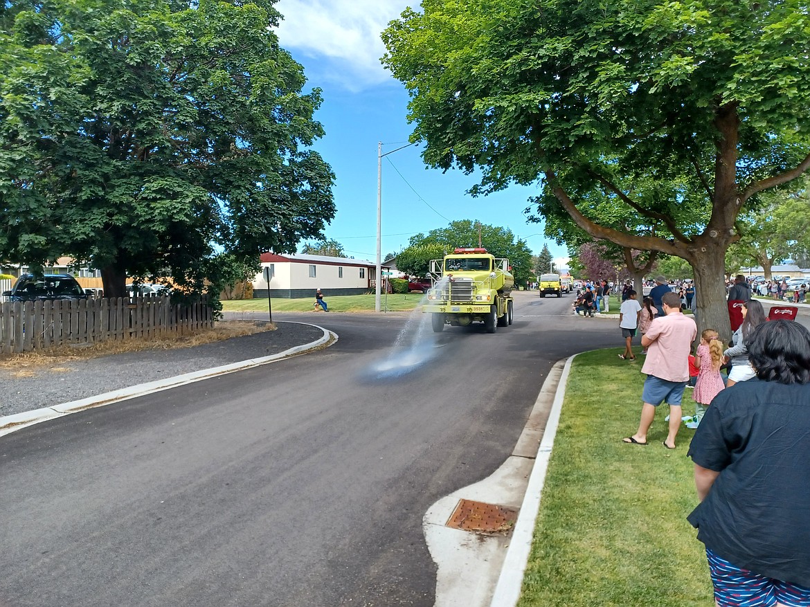 A fire truck waters the road - and sometimes the crowd - during the July 4 parade in George in 2022.