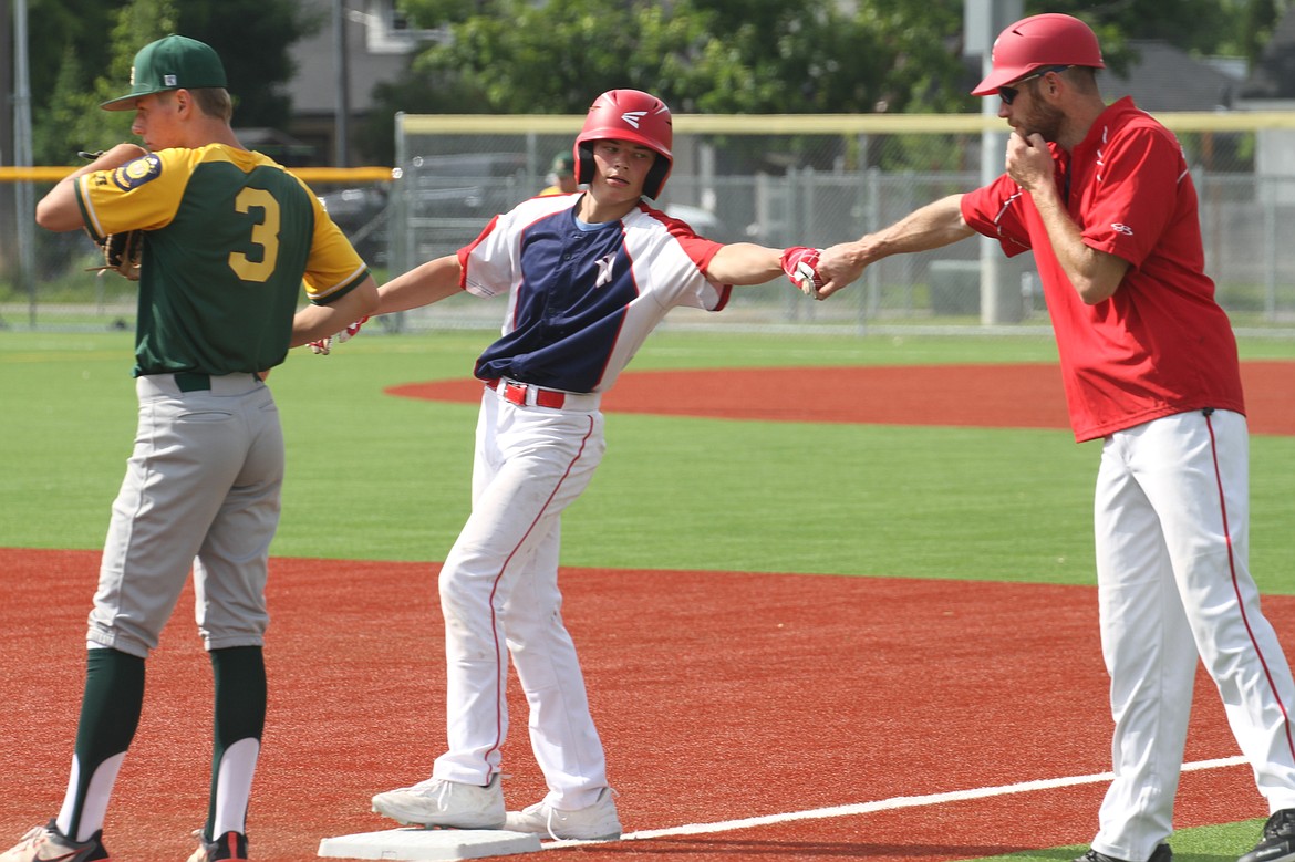 Jayden Kuprienko fist bumps his first base coach after a line drive single to center field.