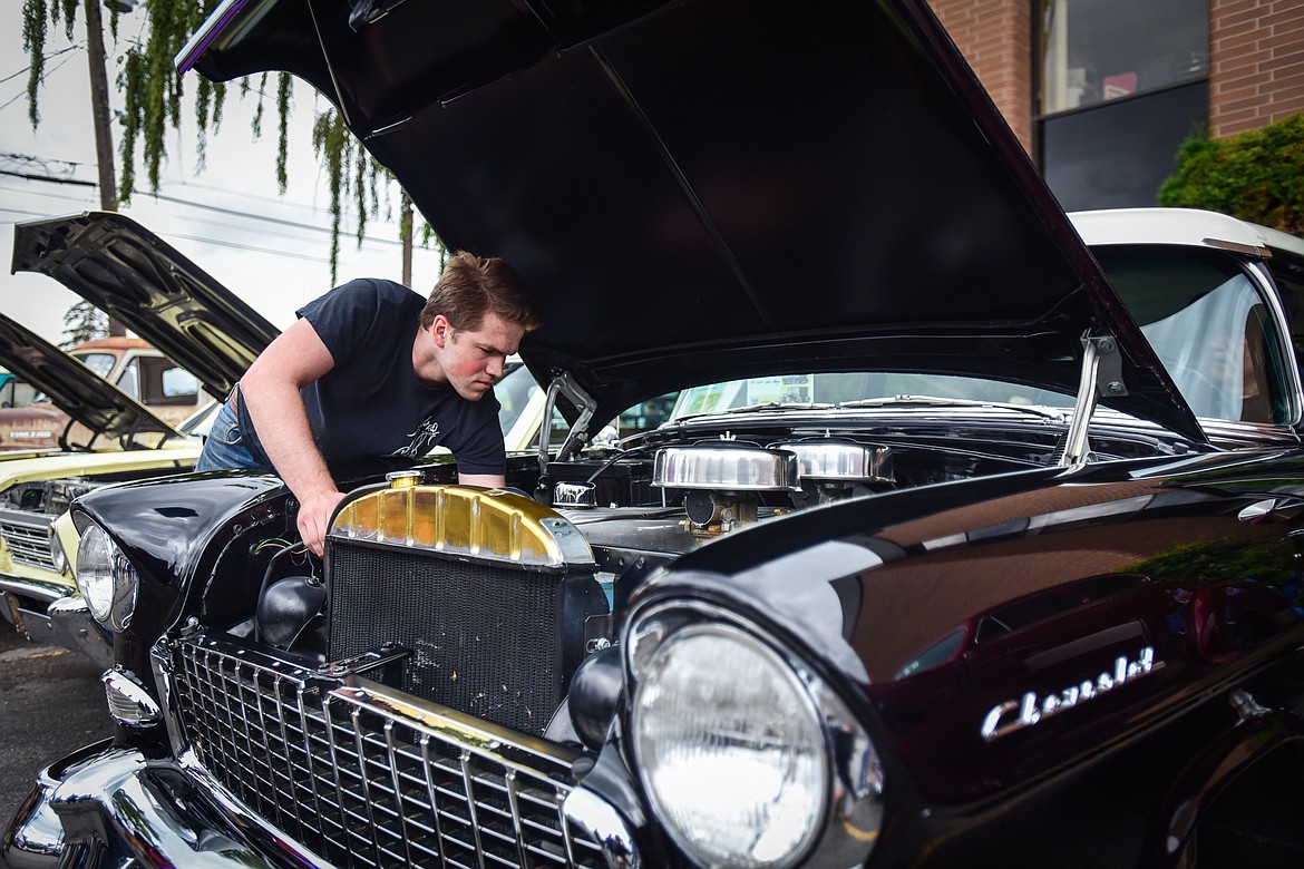 Nate Drobish works under the hood of Max Childs' 1955 Chevy Del Ray at The Big Shindig outside The DeSoto Grill in Kalispell on Saturday, June 17. The Big Shindig features a wide range of classic and custom vehicles as well as live music, barbeque, beer and wine and a pin-up polar plunge. Hosted the Glacier Street Rod Association and the Desoto Grill, money raised benefits Mikayla’s Miracles and Blessings Foundation. (Casey Kreider/Daily Inter Lake)