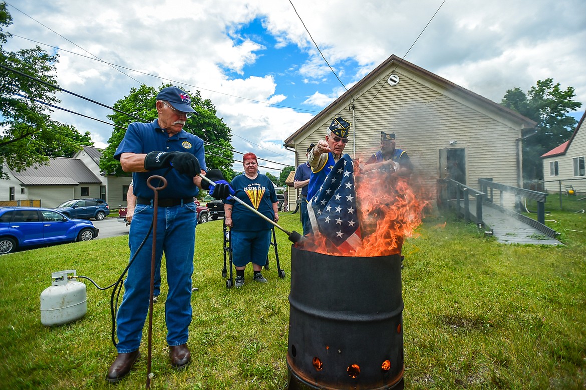 Members of Kalispell American Legion Post 137 and Auxiliary Unit 137 hold a flag retirement ceremony to respectfully dispose of worn, tattered and faded American flags outside their headquarters on Saturday, June 17. (Casey Kreider/Daily Inter Lake)