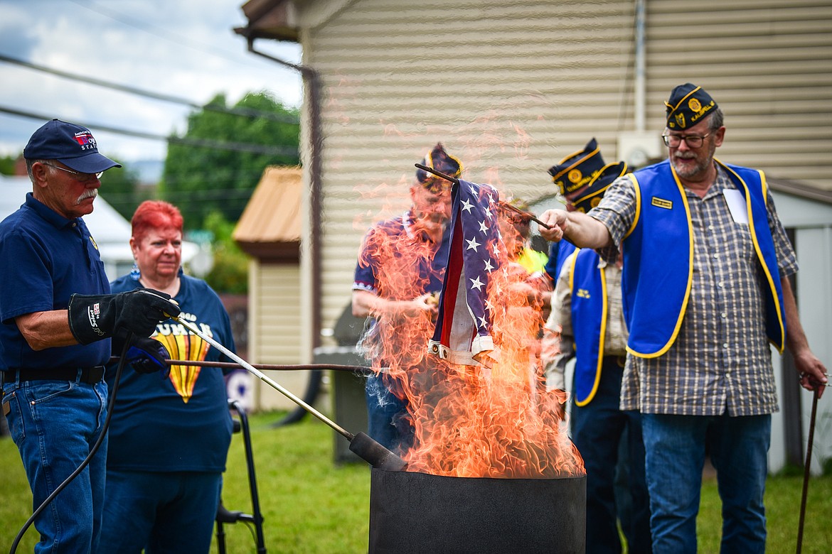 Members of Kalispell American Legion Post 137 and Auxiliary Unit 137 hold a flag retirement ceremony to respectfully dispose of worn, tattered and faded American flags outside their headquarters on Saturday, June 17. (Casey Kreider/Daily Inter Lake)