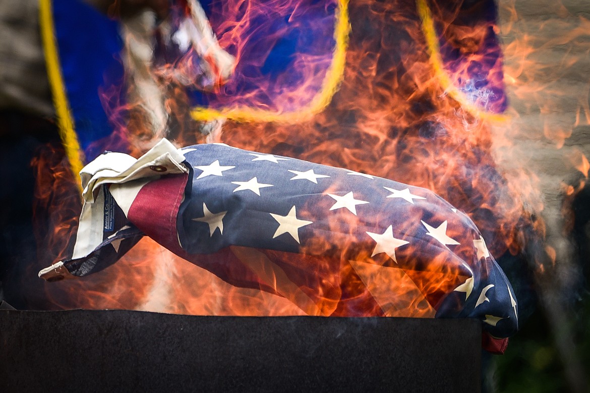 Members of Kalispell American Legion Post 137 and Auxiliary Unit 137 hold a flag retirement ceremony to respectfully dispose of worn, tattered and faded American flags outside their headquarters on Saturday, June 17. (Casey Kreider/Daily Inter Lake)