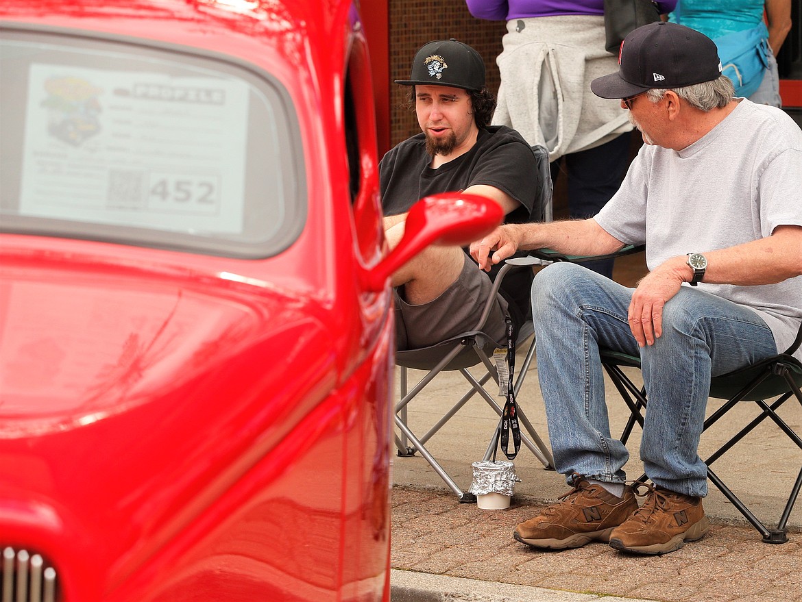 Larry McNeil chats with grandson Jesse Durham as they sit by his 1935 Ford during Saturday's Car d'Lane in downtown Coeur d'Alene.