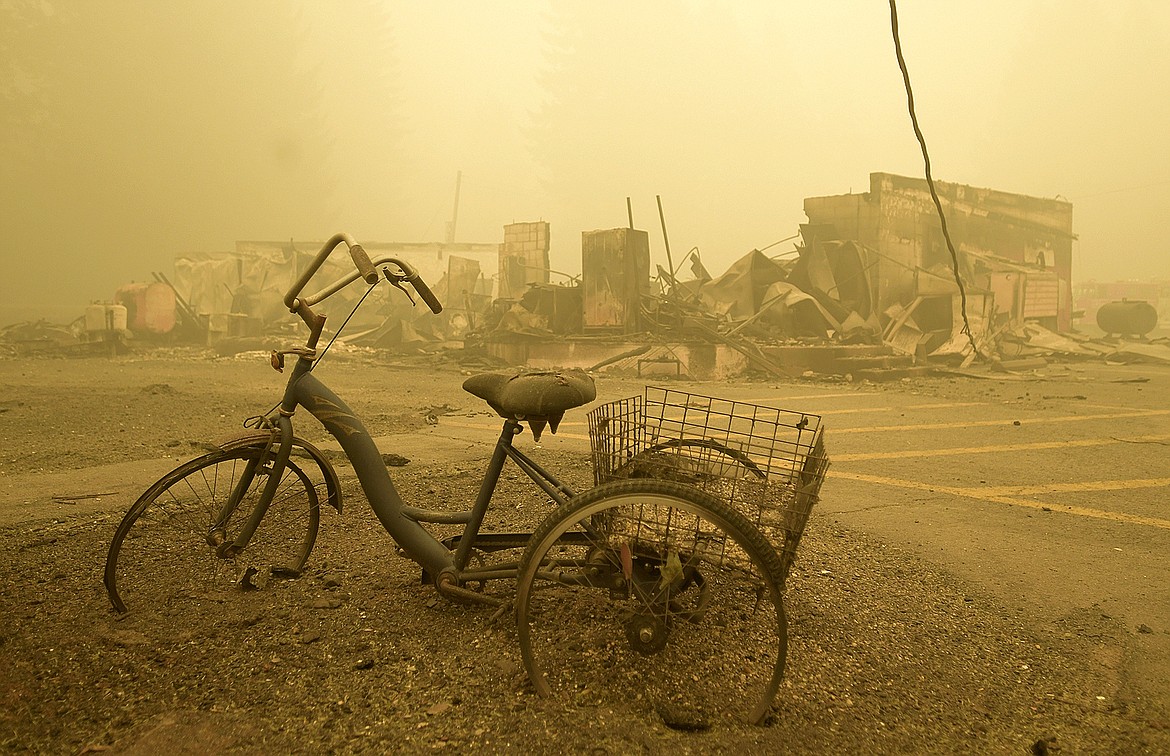 FILE - A trike stands near the burnt remains of a building destroyed by a wildfire near the Lake Detroit Market in Detroit, Ore., Sept. 11, 2020. A jury verdict that found power company PacifiCorp liable for devastating wildfires in Oregon in 2020 is highlighting the legal and financial risks utilities face if they fail to take proper precautions for climate change. (Mark Ylen/Albany Democrat-Herald via AP, File)