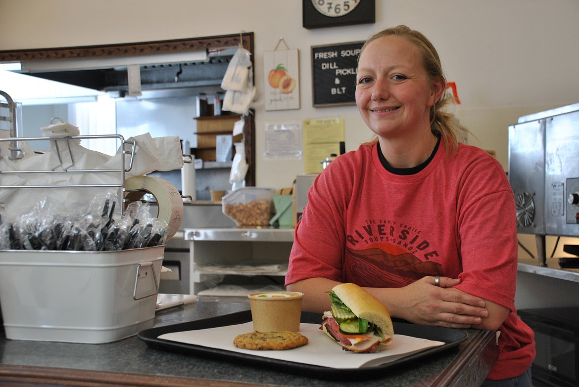 With a club sandwich on her freshly baked bread, and some homemade Dill Pickle soup, owner of River Side Soups and Sandz, Bailey Moree, leans across her serving counter last Thursday after finishing up a large order of sandwiches for a local construction crew. (Mineral Independent/Amy Quinlivan)